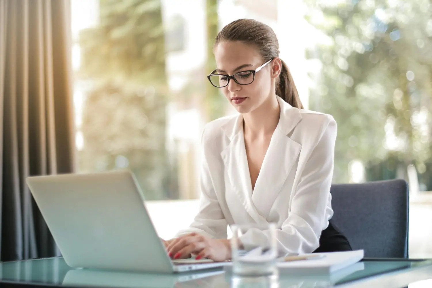 SAIA Personalservice, eine berufstätige Frau, die an einem Schreibtisch sitzt und den Laptop benutzt